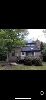a house with a tree in front of it at Pocono House in a private community 4 pools, Lake. in Tobyhanna