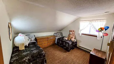 a bedroom with a teddy bear sitting on a chair at Pocono House in a private community 4 pools, Lake. in Tobyhanna