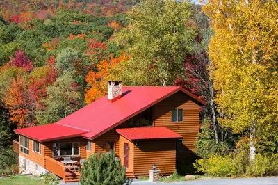 a log cabin with a red roof at Birch Creek Lodge in Pine Hill