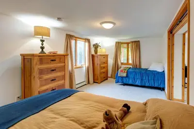 a bedroom with a bed with a teddy bear laying on it at Birch Creek Lodge in Pine Hill