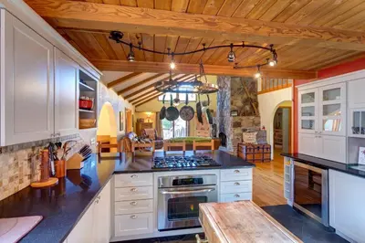 a kitchen with white cabinets and a stove top oven at Birch Creek Lodge in Pine Hill
