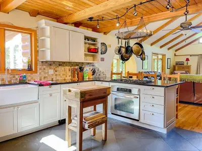 a kitchen with white cabinets and a stove top oven at Birch Creek Lodge in Pine Hill