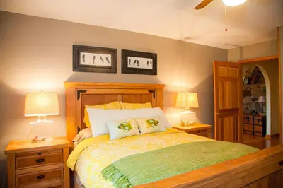 a bedroom with a bed with two lamps and two tables at Birch Creek Lodge in Pine Hill