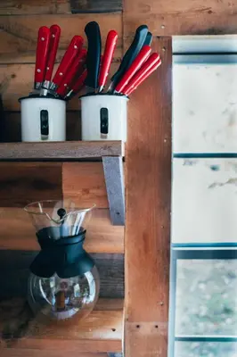 a wooden shelf with utensils in cups on it at Mountain Brook Cabin in Bovina Center