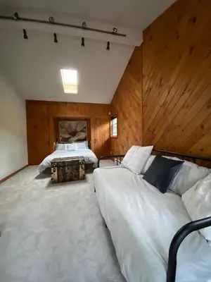 a large bedroom with two beds and wooden walls at Hunter Mountain Sanctuary in Hunter