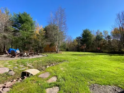 a grassy field with a picnic table in the background at Hunter Mountain Sanctuary in Hunter