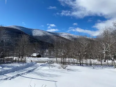a snow covered field with a mountain in the background at Hunter Mountain Sanctuary in Hunter