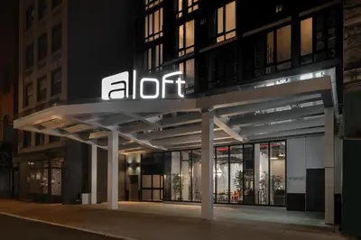 an illuminated entrance to an office building at night at Aloft New York Chelsea in New York