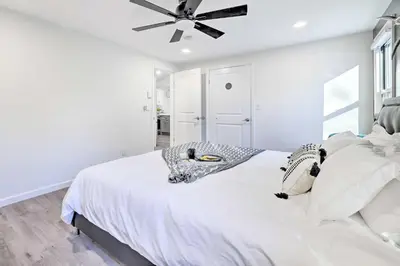 a white bedroom with a bed with a ceiling fan at Game Room! Tobyhanna Retreat 17 Mi to Ski Slopes in Tobyhanna