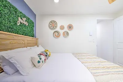 a bedroom with a white bed with a green painting on the wall at Game Room! Tobyhanna Retreat 17 Mi to Ski Slopes in Tobyhanna