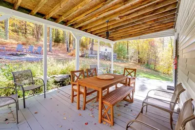 a porch with a wooden table and chairs at The Heatherwood in Bovina Center