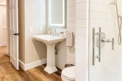 a bathroom with a sink and a toilet and a mirror at The Heatherwood in Bovina Center