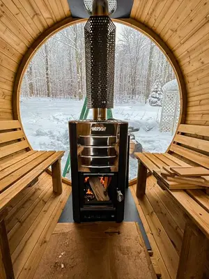 a wood stove in a cabin with two benches at The Heatherwood in Bovina Center