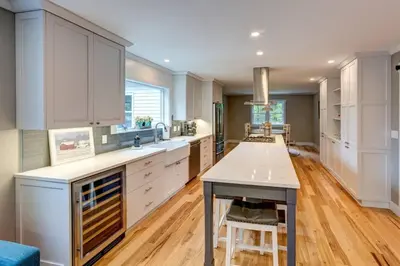 a large kitchen with white cabinets and a table at The Heatherwood in Bovina Center