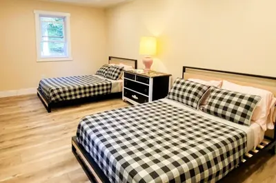 a bedroom with two beds and a table with a lamp at The Heatherwood in Bovina Center