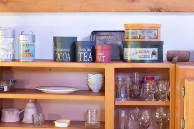 a shelf with glasses and other items on it at Rustic Roost Cabin in Vega