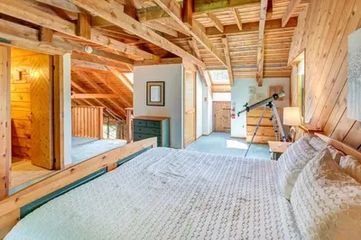 a bedroom with a large bed in a wooden house at Rustic Roost Cabin in Vega