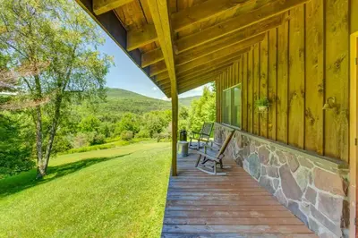 a porch of a wooden house with a bench on it at Rustic Roost Cabin in Vega