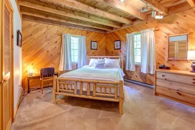 a bedroom with a bed in a wooden room at Rustic Roost Cabin in Vega