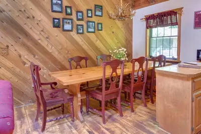 a dining room with a wooden table and chairs at Rustic Roost Cabin in Vega