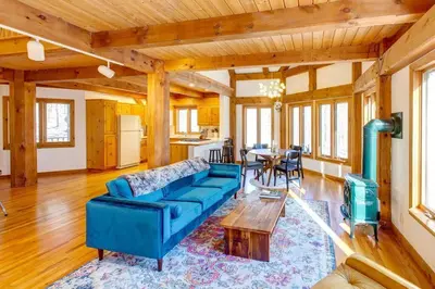 a living room with a blue couch and a table at Catskills Enchanted Forest in Bloomville