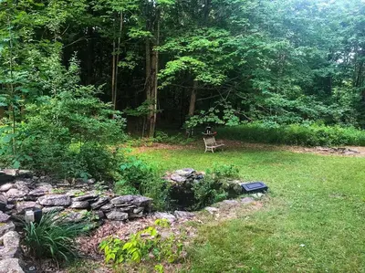 a dog sitting on a bench in a yard at Catskills Enchanted Forest in Bloomville