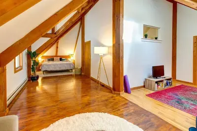 a attic room with a bed and a television at Catskills Enchanted Forest in Bloomville