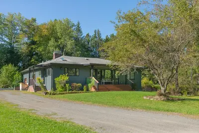 a green house with a road in front of it at Elenas by the Mill in East Meredith