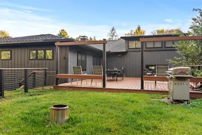 a house with a deck with a table on it at Elenas by the Mill in East Meredith