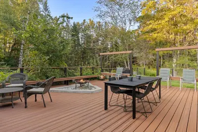 a wooden deck with a table and chairs on it at Elenas by the Mill in East Meredith
