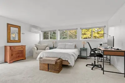 a bedroom with a bed and a desk with a computer at Elenas by the Mill in East Meredith