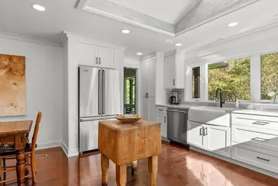 a kitchen with white cabinets and a stainless steel refrigerator at Elenas by the Mill in East Meredith