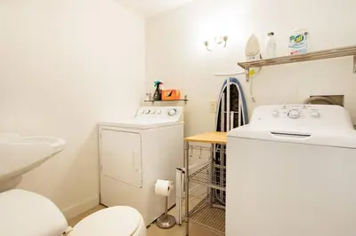 a bathroom with a toilet and a washer and dryer at Cloud Crowd in Bloomville