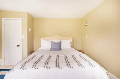a bedroom with a large white bed with a blue pillow at Cloud Crowd in Bloomville