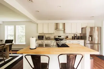 a kitchen with white cabinets and a wooden counter top at Cloud Crowd in Bloomville