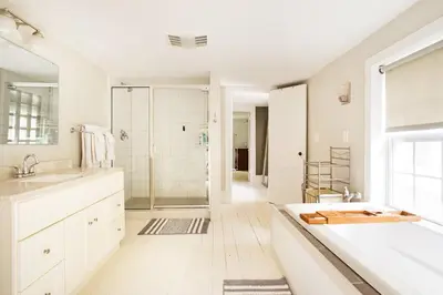 a white bathroom with a shower and a sink at Cloud Crowd in Bloomville