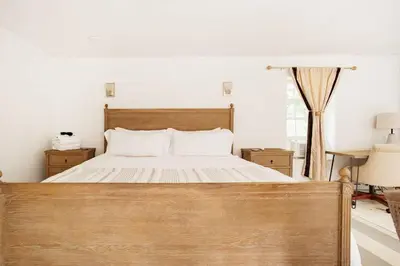 a bedroom with a large wooden bed with white sheets at Cloud Crowd in Bloomville