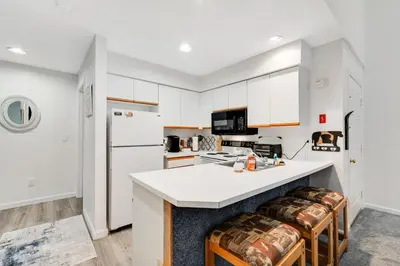 a kitchen with white cabinets and a white counter top at Skiing Haven in Dover