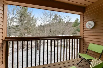 a screened porch with a large window and a green chair at Skiing Haven in Dover
