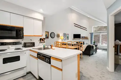 a kitchen with white appliances and a living room at Skiing Haven in Dover