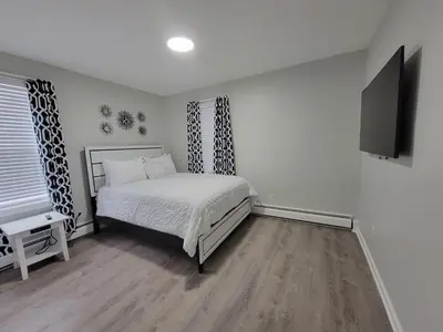 a bedroom with a bed and a flat screen tv at One room for rent shared bathroom and kitchen in Hartford