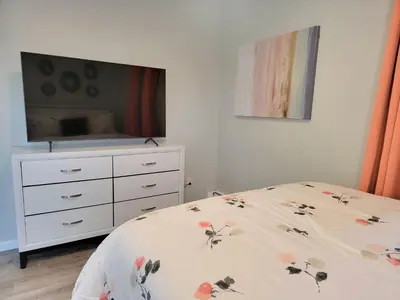 a bedroom with a bed with a dresser and a tv at One room for rent shared bathroom and kitchen in Hartford
