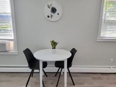 a white table with two chairs and a clock on the wall at One room for rent shared bathroom and kitchen in Hartford