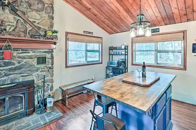 a kitchen with a stone fireplace and a table at Cozy Catskills Escape, 3 Mi to Plattekill Mtn in Roxbury