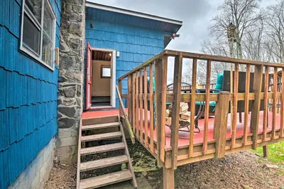 a wooden deck with a table on a blue house at Cozy Catskills Escape, 3 Mi to Plattekill Mtn in Roxbury