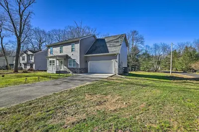 a white house with a garage on a street at Community Beach and Lake Pocono Summit Escape in Pocono Summit