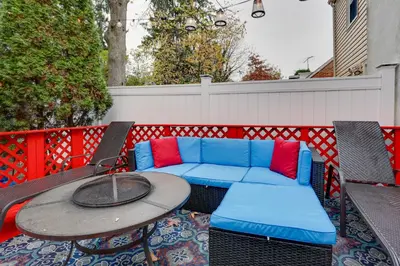a patio with a couch and a table and chairs at Newark Home with Deck and Fire Pit, 16 Mi to NYC! in Newark