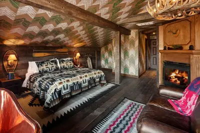 a bedroom with a bed and a fireplace at Urban Cowboy Lodge in Big Indian