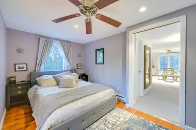 a bedroom with a bed and a ceiling fan at Cozy Dix Hills Apt with Deck about 7 Mi to Beach! in Dix Hills