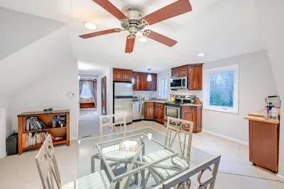 a kitchen with a ceiling fan and a glass table at Cozy Dix Hills Apt with Deck about 7 Mi to Beach! in Dix Hills